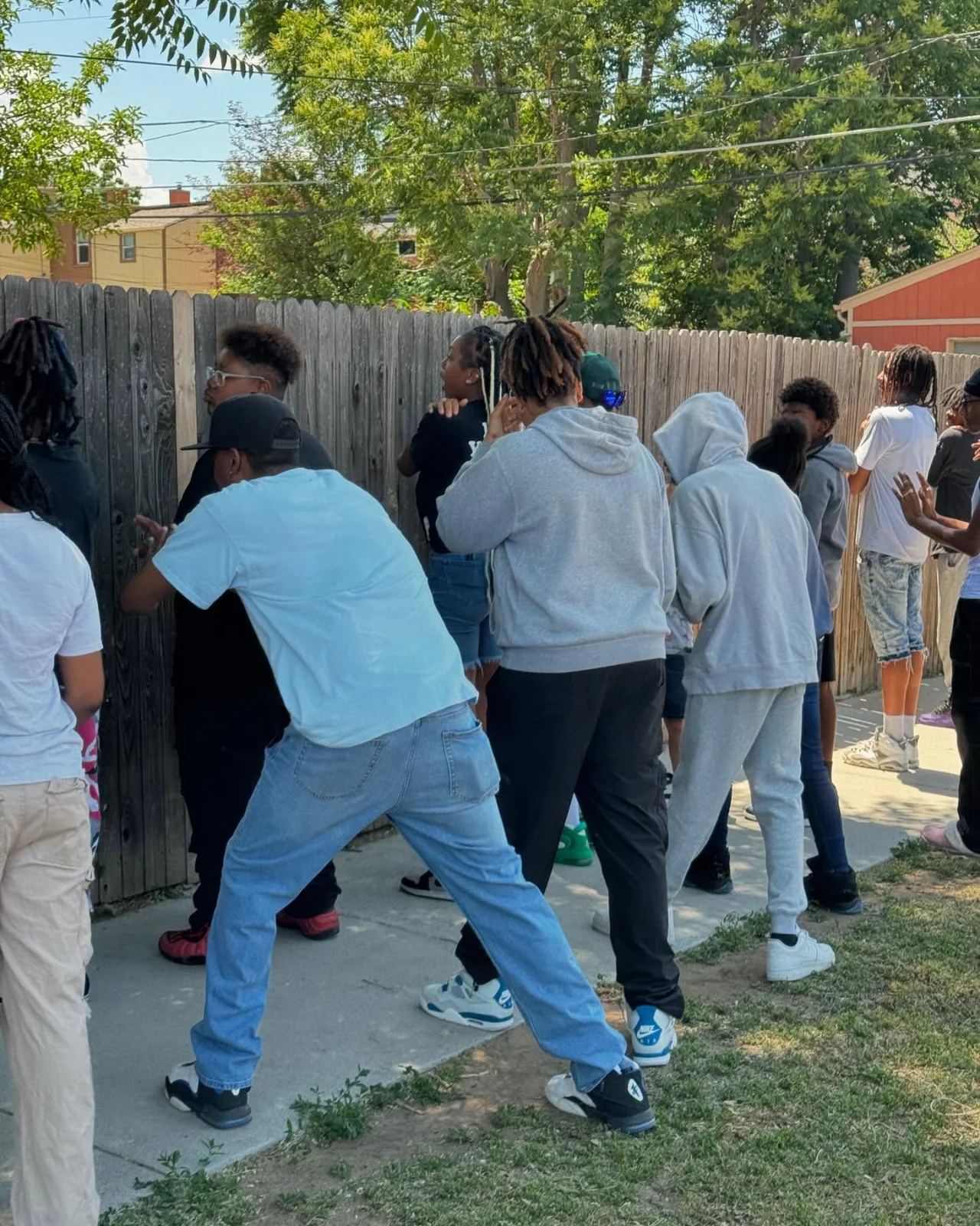 A youth activity taking place near a fence outdoors