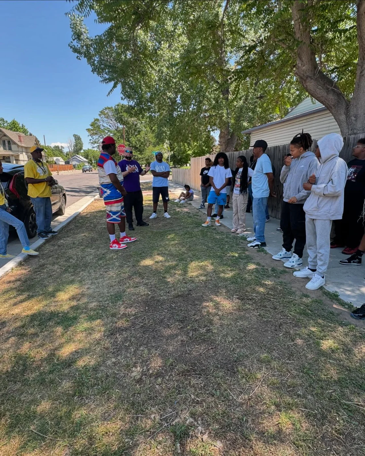 A youth group gathered outdoors in a neighborhood circle