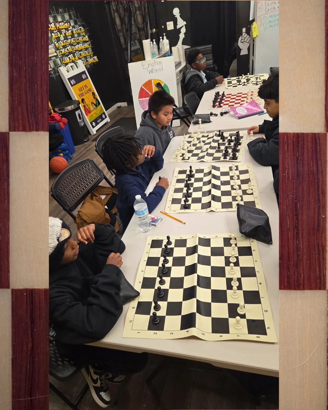 Youth playing chess in a room viewed through a doorway