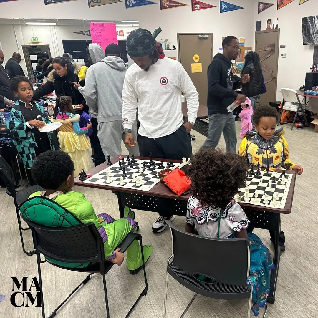 Children and families around a chess table during a community event